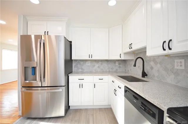 a kitchen with a refrigerator sink and cabinets