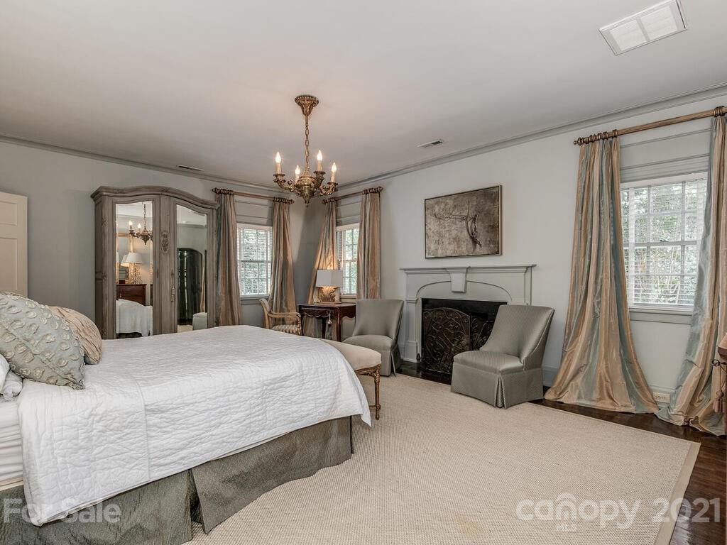 2001 Queens Road East Charlotte, NC 28207 - Photo 19 of 39 a bedroom with a large bed and a chandelier