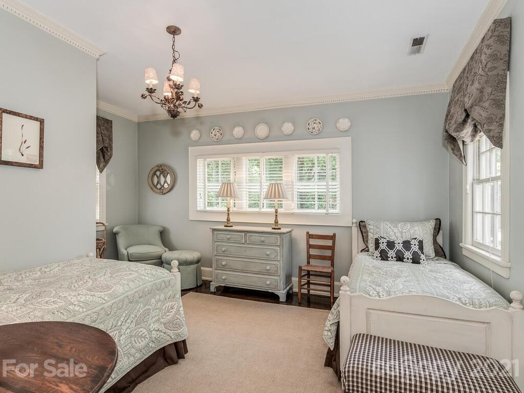 2001 Queens Road East Charlotte, NC 28207 - Photo 24 of 39 a bedroom with a large bed and a chandelier