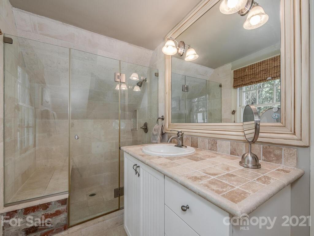 2001 Queens Road East Charlotte, NC 28207 - Photo 30 of 39 a bathroom with a granite countertop sink a mirror and a shower