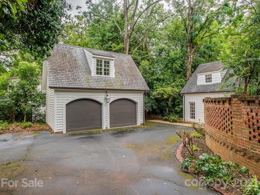 2001 Queens Road East Charlotte, NC 28207 - Photo 35 of 39 a view of a grey house with large windows and a small yard
