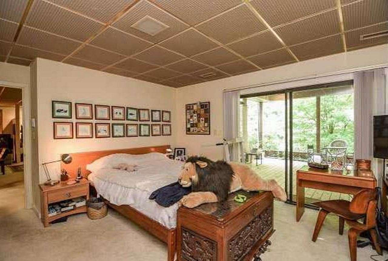 6909 Slade Hill Road Raleigh, NC 27615 - Photo 22 of 25 Large bedroom with access to huge private covered porch overlooking flowering trees and koi pond. Other access to porch by stone walkway directly outside. 2nd bedroom is ample but currently filled with boxes to be moved. Lower Level Master Bedroom