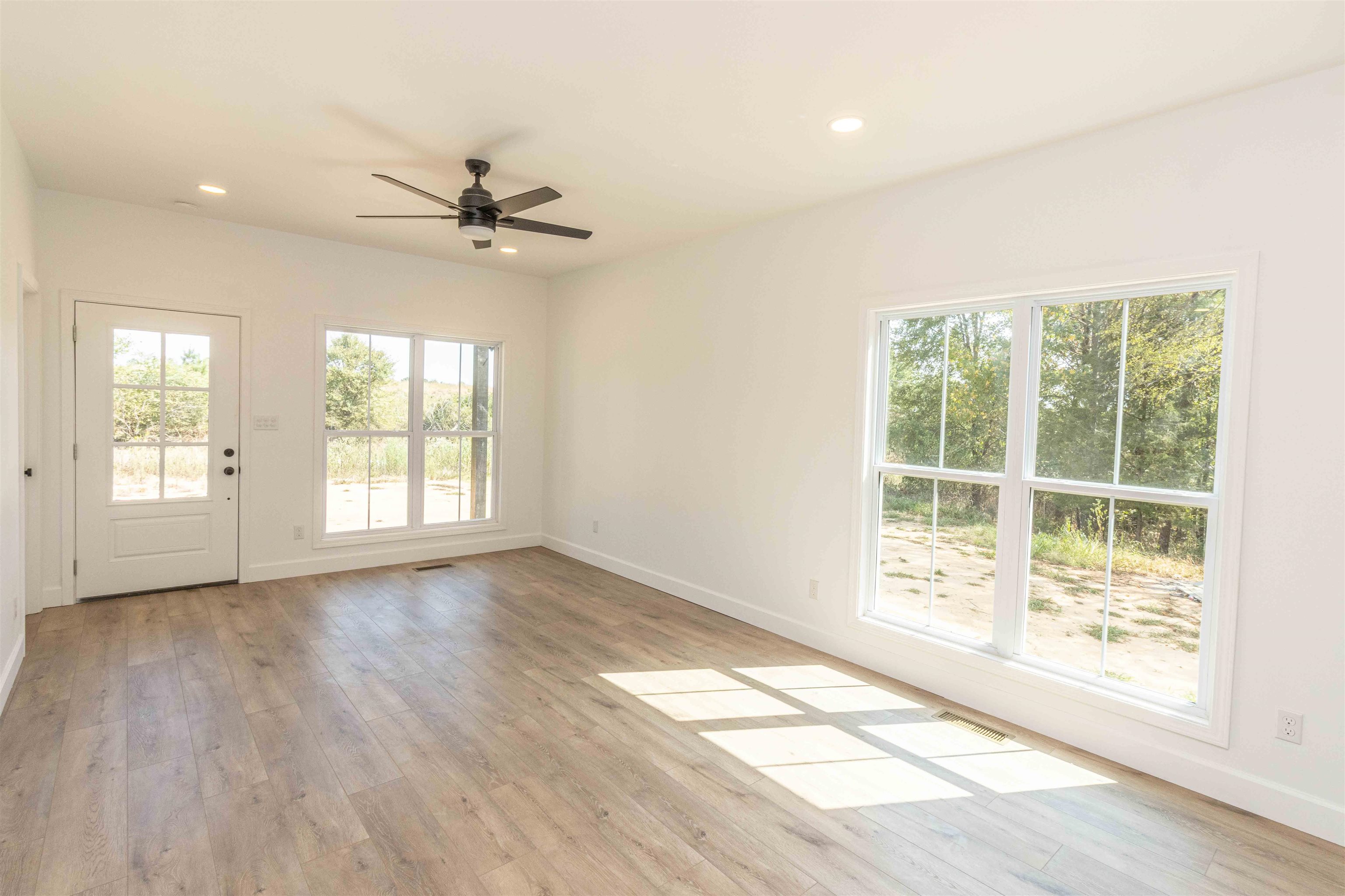 775 Airport Road Selmer, TN 38375 - Photo 6 of 20 a view of an empty room with a window and wooden floor