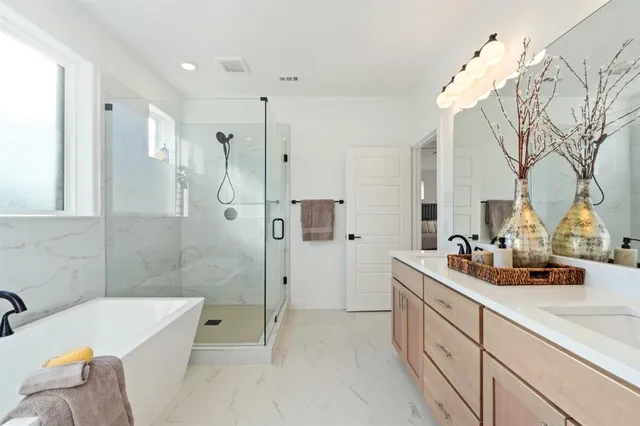 a bathroom with a sink tub shower and a mirror