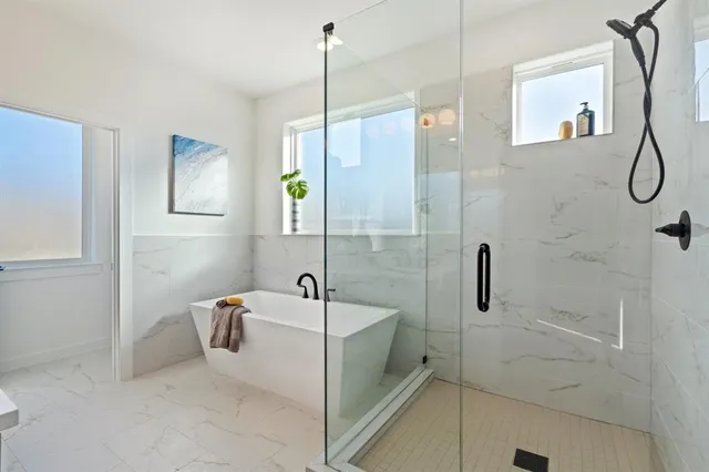 a bathroom with a tub a sink and shower