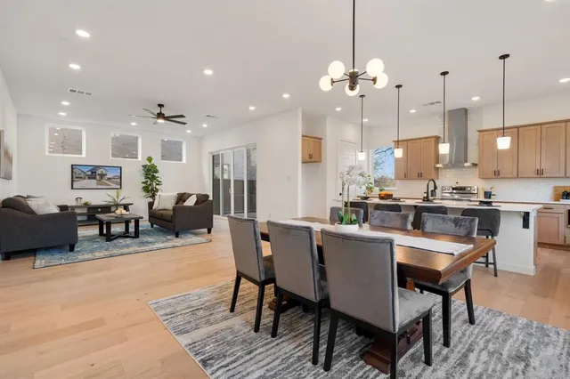 a dining room filled a chandelier a glass table and chairs