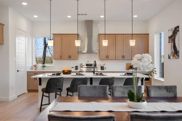 a kitchen with stainless steel appliances granite countertop a sink refrigerator and cabinets