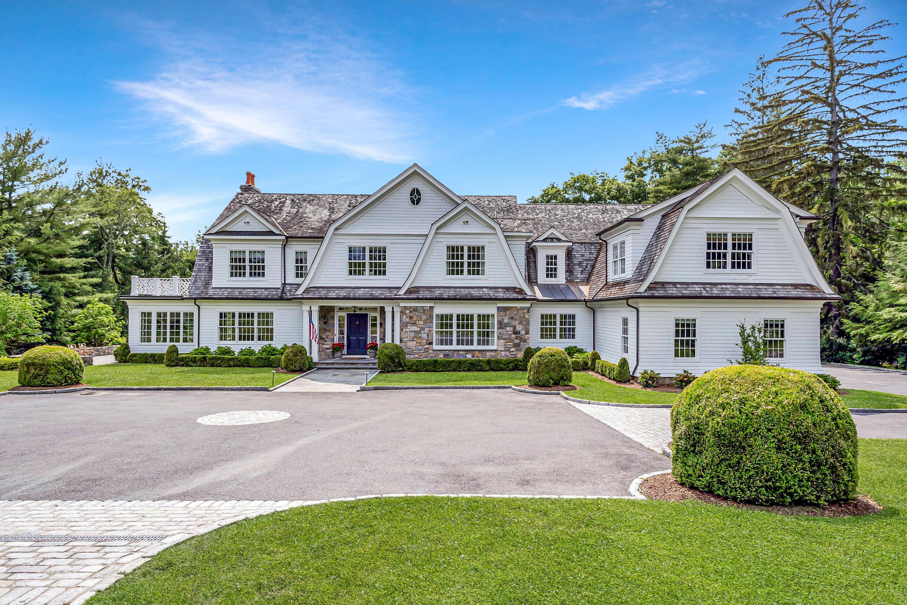 a front view of a house with a yard and trees