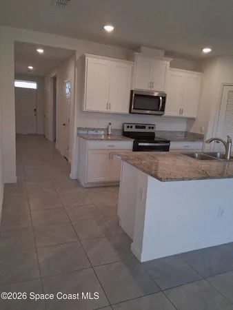 a kitchen with a sink a stove a refrigerator and a cabinets