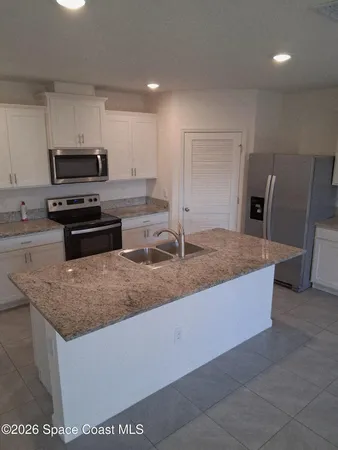 a kitchen with stainless steel appliances granite countertop a sink a stove and a refrigerator