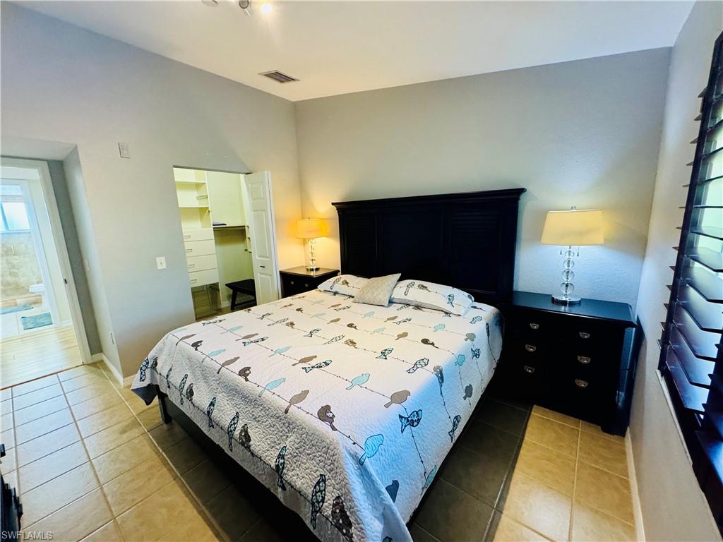 8244 Key Royal Circle, Unit 633 Naples, FL 34119 - Photo 11 of 28 a bedroom with a bed and a dresser