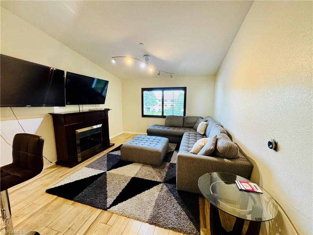 8244 Key Royal Circle, Unit 633 Naples, FL 34119 - Photo 2 of 28 a living room with furniture and a fireplace