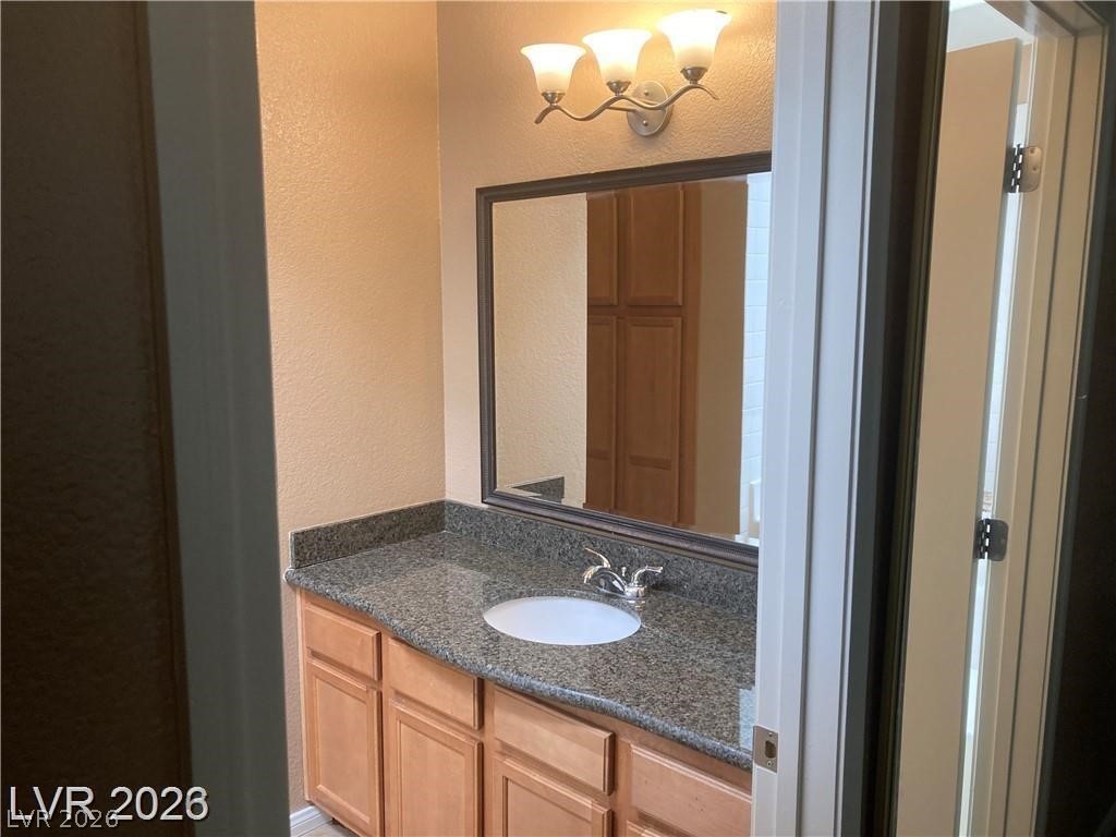 3145 East Flamingo Road, Unit 2100 Las Vegas, NV 89121 - Photo 20 of 34 A well-lit vanity with granite counters and a clean, inviting atmosphere.