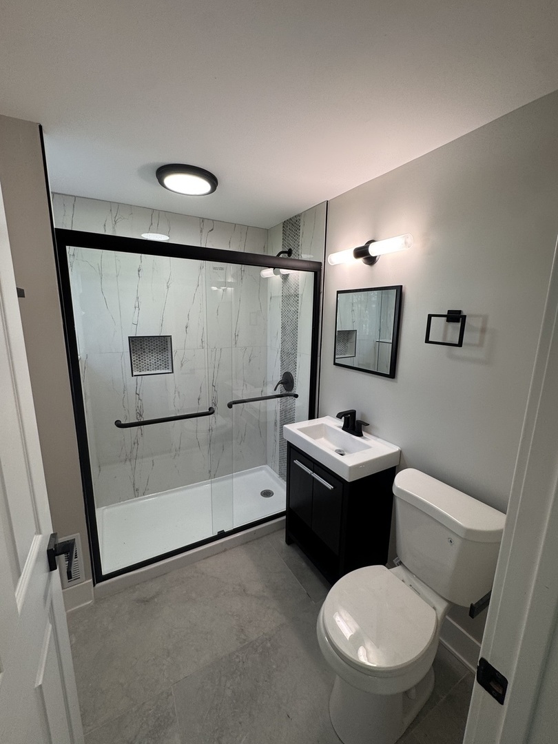 18314 Locust Street Lansing, IL 60438 - Photo 8 of 14 a bathroom with a toilet sink and mirror