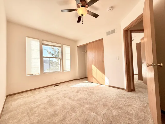 an empty room with fan and windows
