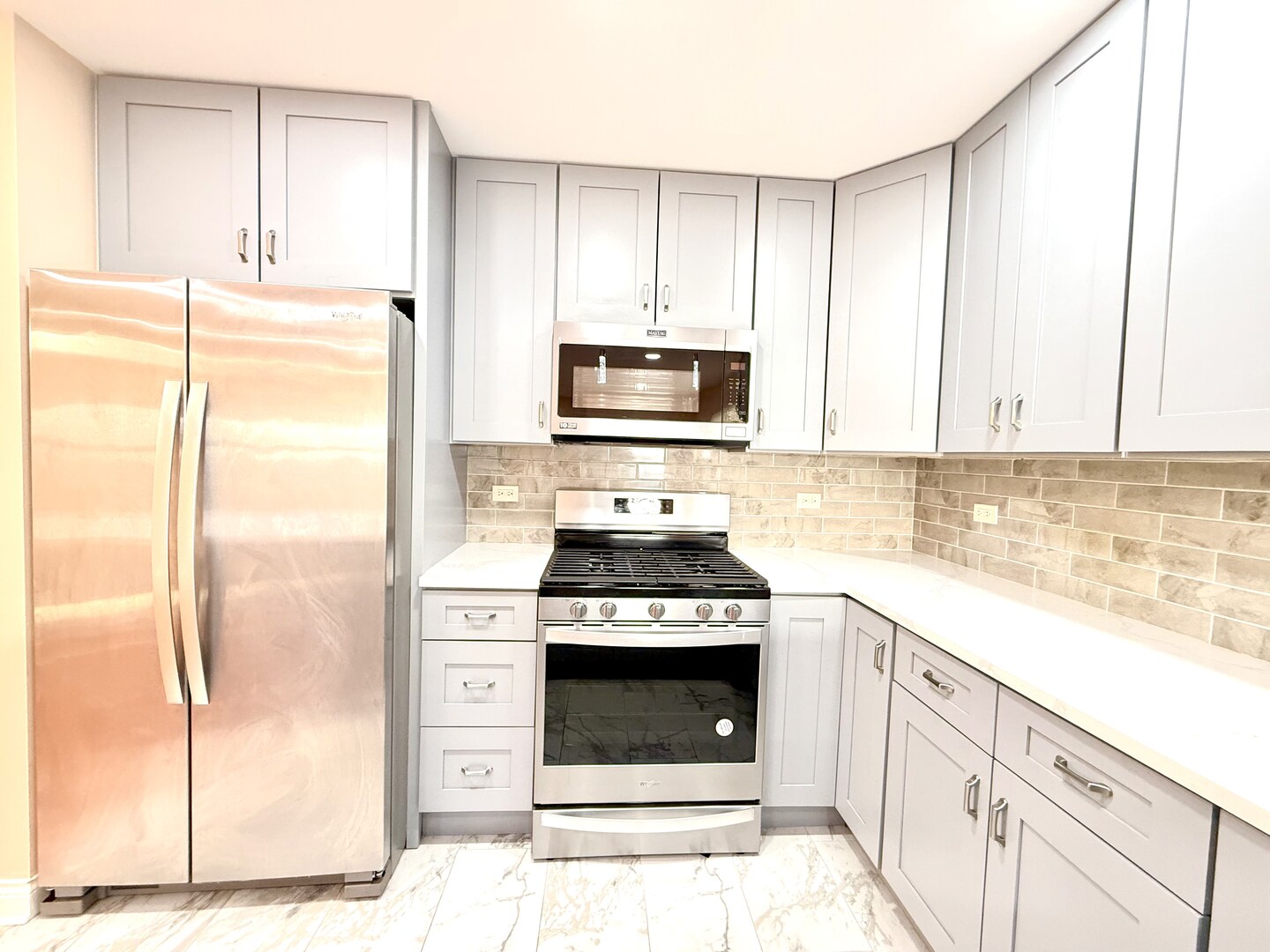 138 Mountain Laurel Court Romeoville, IL 60446 - Photo 7 of 26 a kitchen with granite countertop a stove top oven microwave and refrigerator