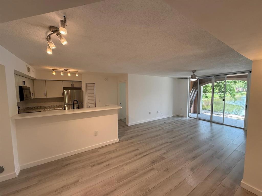 a view of a kitchen with a sink wooden floor and a living room