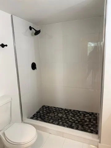 a bathroom with a toilet and a shower