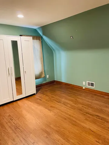 an empty room with wooden floor and closet