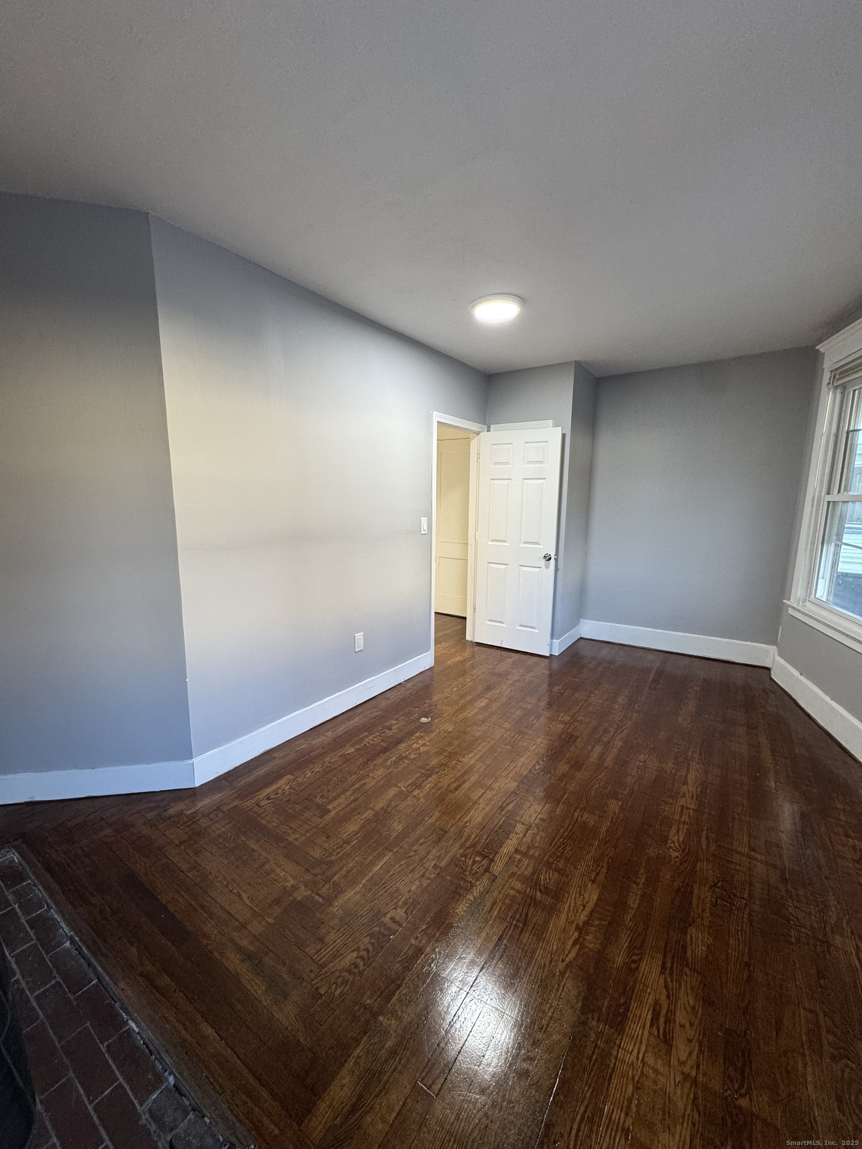 1528 Ella T Grasso Boulevard, Unit 2 New Haven, CT 06511 - Photo 9 of 10 an empty room with wooden floor and windows