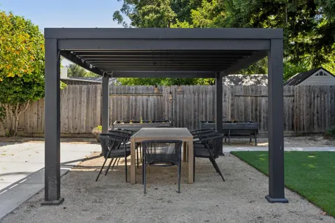 a view of backyard with table and chairs and a small cabin