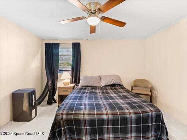 322 3rd Street Merritt Island, FL 32953 - Photo 19 of 37 a bedroom with a bed and a chandelier