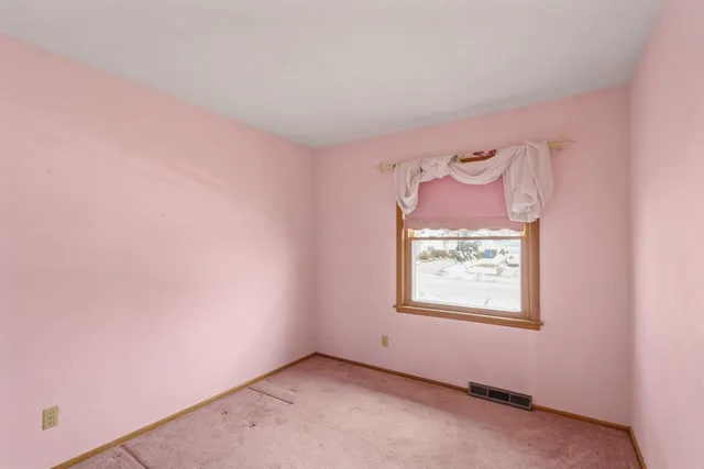 an empty room with a painting on the wall