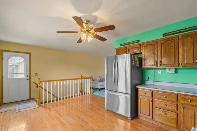 a kitchen with stainless steel appliances granite countertop a refrigerator a oven a sink and dishwasher with wooden floor