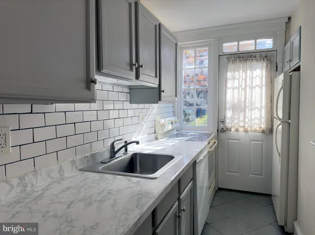 a kitchen with stainless steel appliances granite countertop a sink and a refrigerator