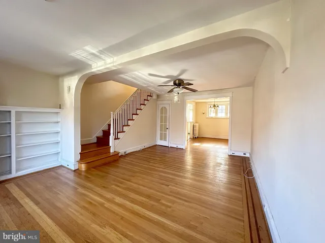 a view of a room with wooden floor staircase and a living room