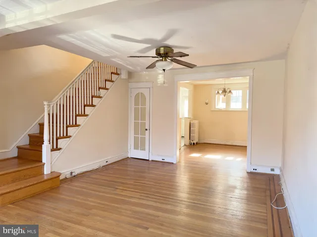 a view of a hallway with wooden floor and staircase