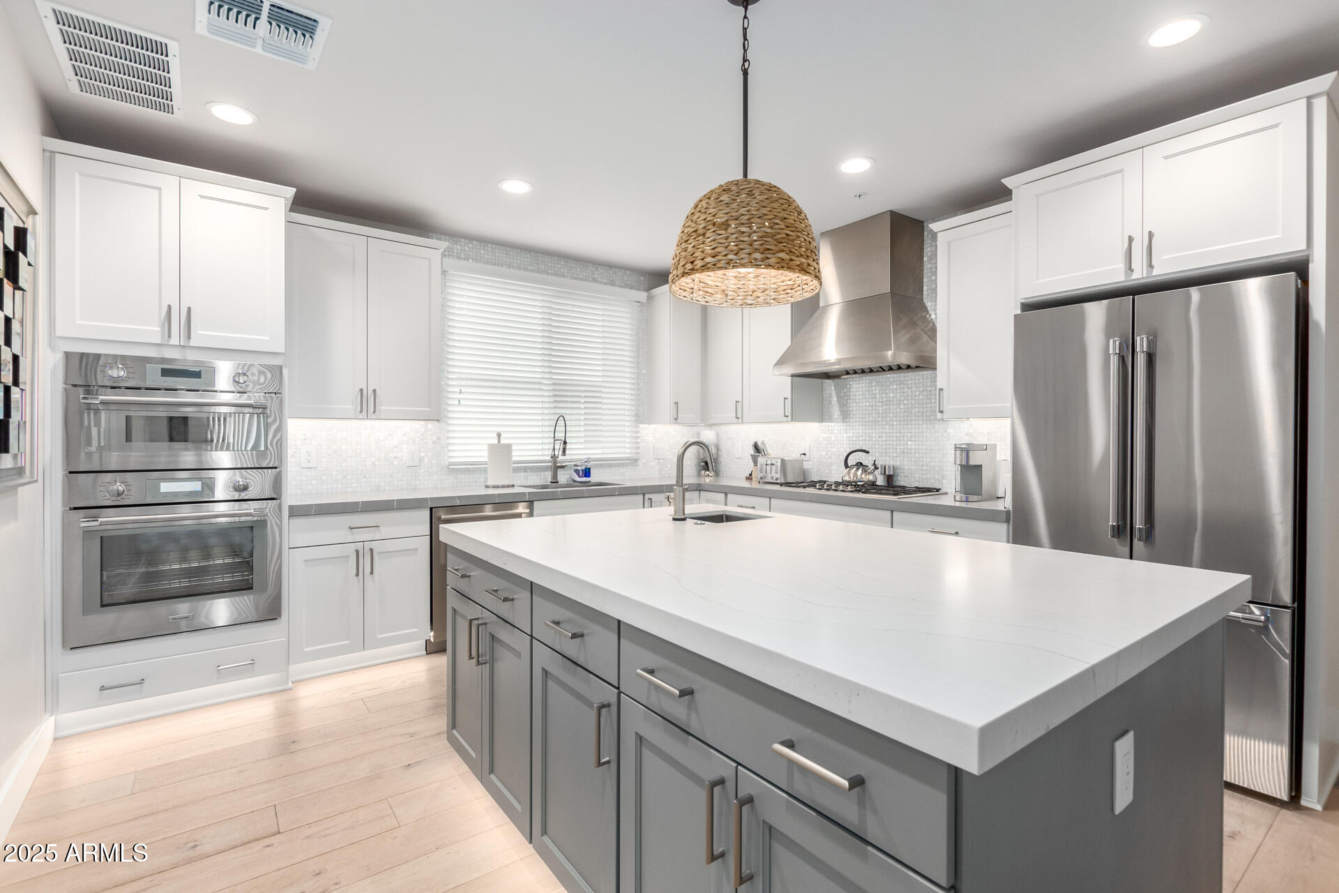 a kitchen with stainless steel appliances granite countertop a sink a stove a refrigerator and a center island