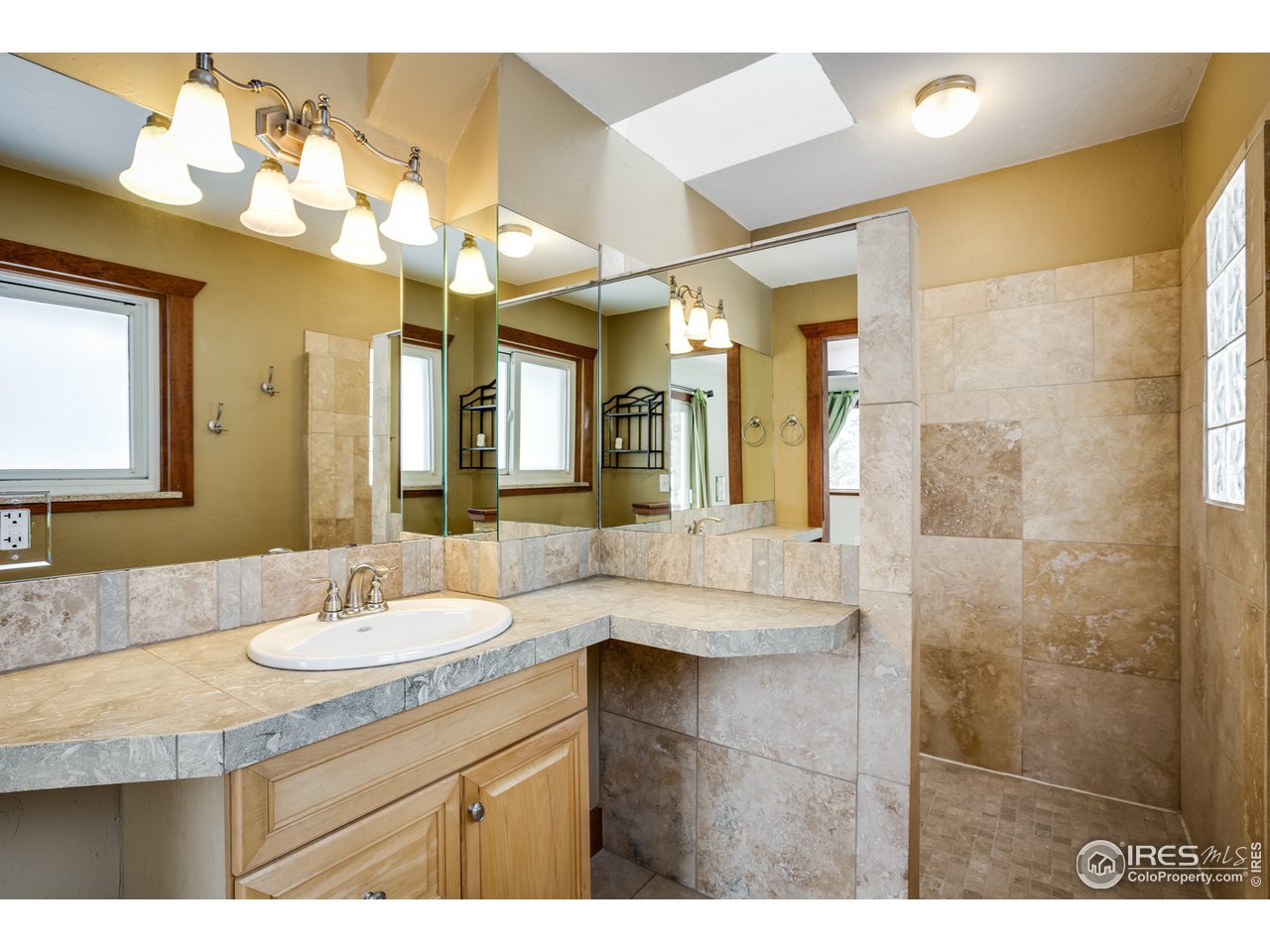 7172 Olde Stage Road Boulder, CO 80302 - Photo 15 of 35 a bathroom with a granite countertop sink a large mirror and a shower