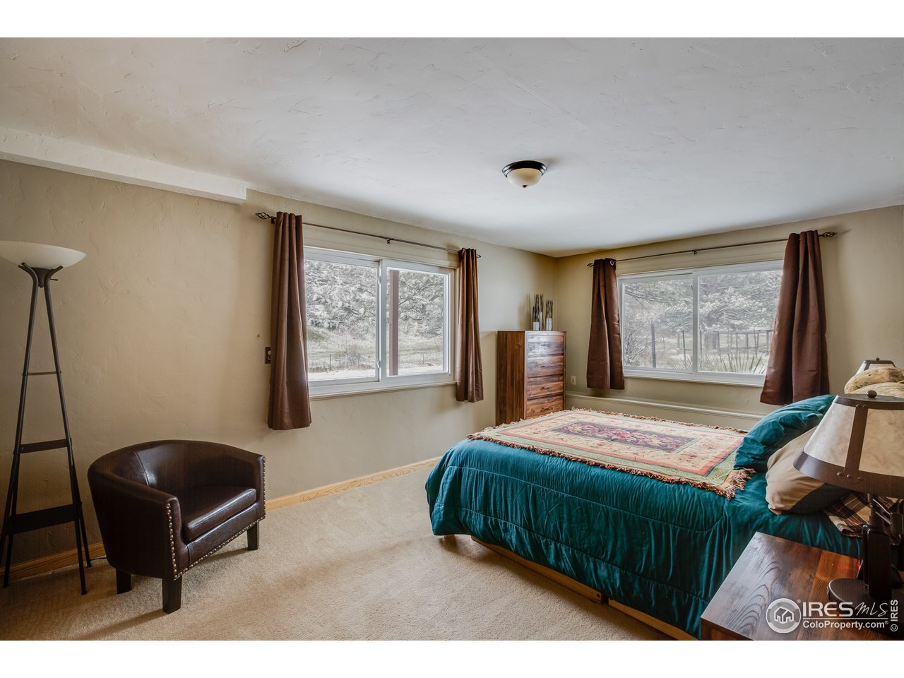 7172 Olde Stage Road Boulder, CO 80302 - Photo 20 of 35 a bedroom with a bed a dresser and chair