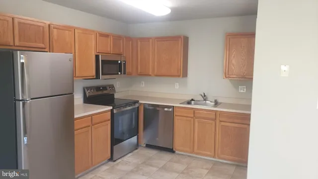 a kitchen with stainless steel appliances granite countertop a refrigerator stove a sink and dishwasher