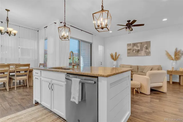 a view of living room kitchen island dining table and wooden floor
