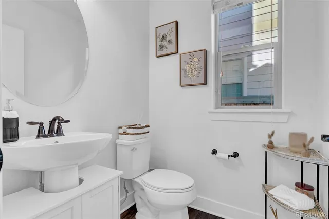 a bathroom with a toilet a sink and mirror