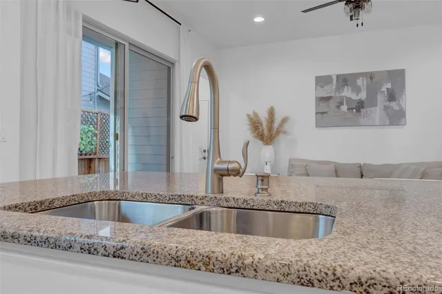 a view of kitchen sink a faucet potted plant and a window