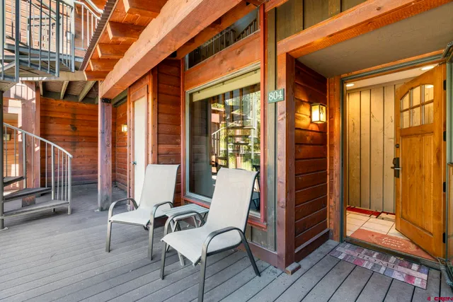 a view of a balcony with wooden floor and furniture