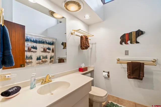 a bathroom with a sink vanity mirror and toilet