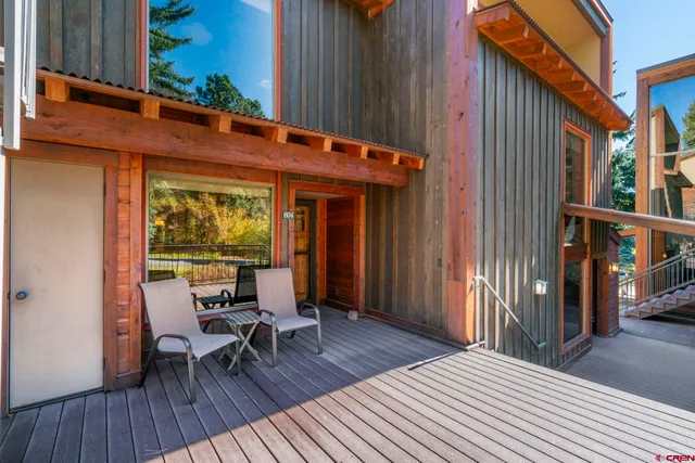 a view of a patio with table and chairs with wooden floor and fence