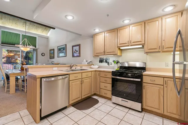 a kitchen with stainless steel appliances granite countertop a stove a sink and a refrigerator