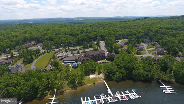 an aerial view of a house with a garden and lake view