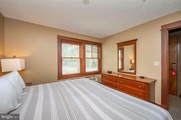 a bedroom with a bed and a large window