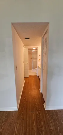 a view of a room with wooden floor and a hallway
