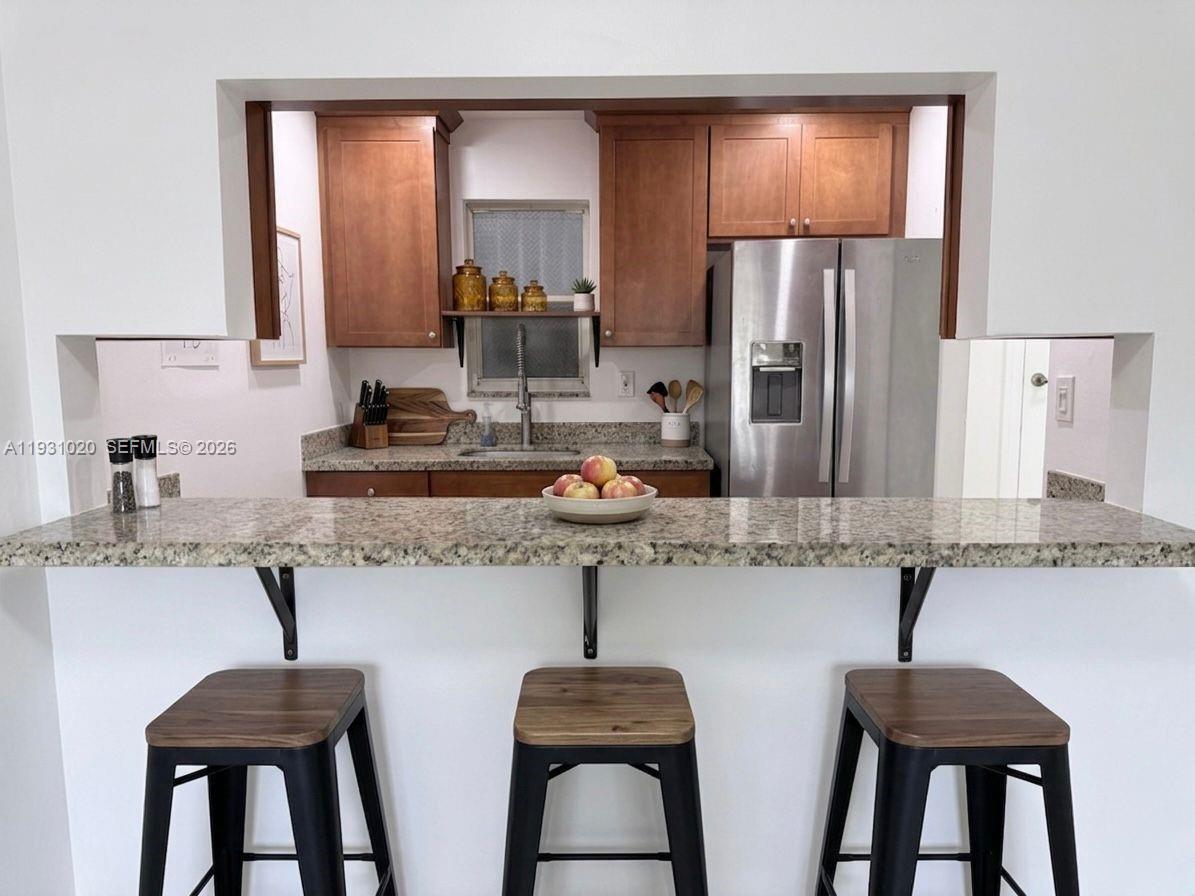 160 Southwest 30th Avenue, Unit 104A Miami, FL 33135 - Photo 12 of 32 a kitchen with stainless steel appliances a sink and a refrigerator