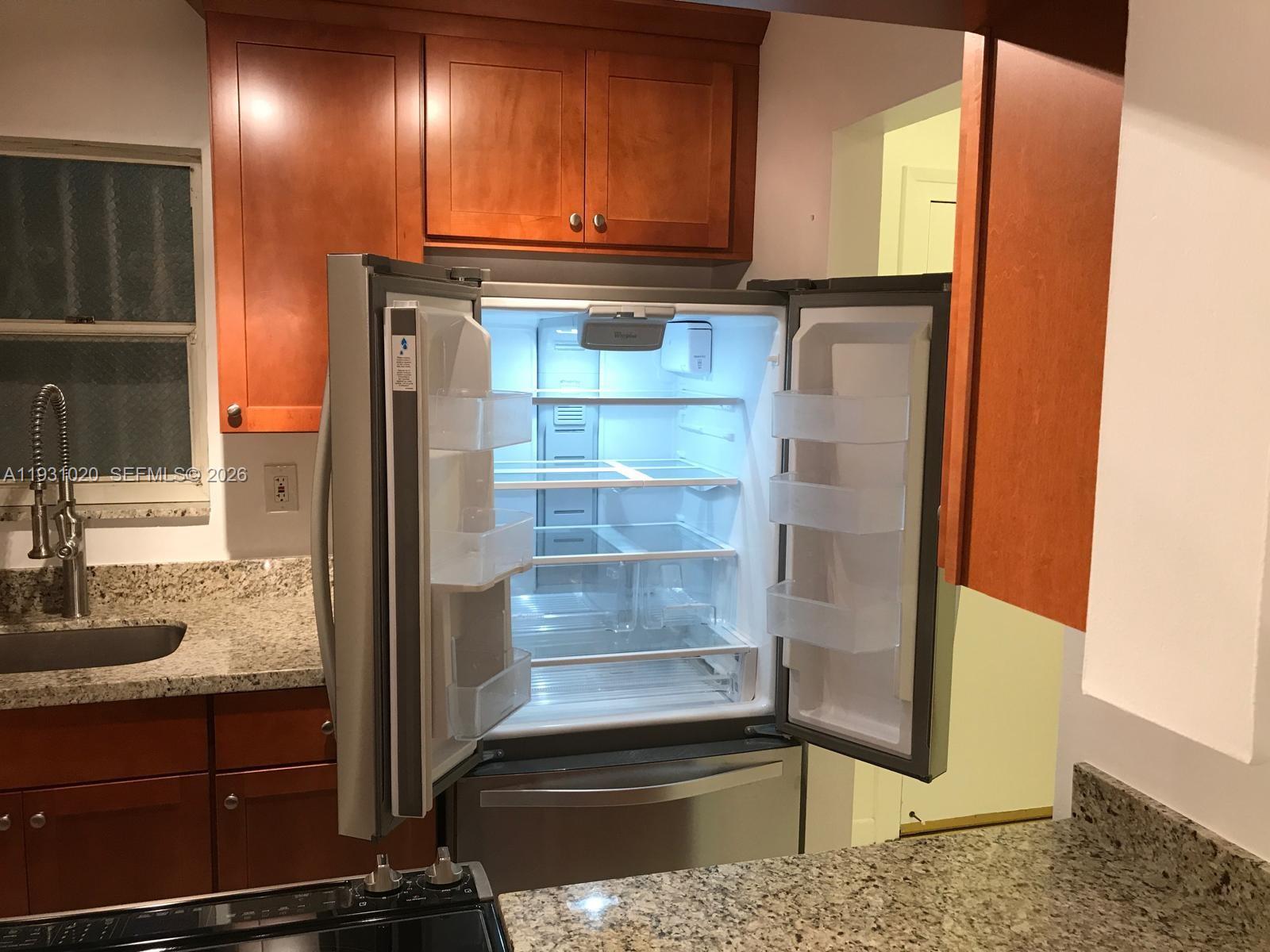 160 Southwest 30th Avenue, Unit 104A Miami, FL 33135 - Photo 2 of 24 a kitchen with granite countertop a refrigerator and a sink