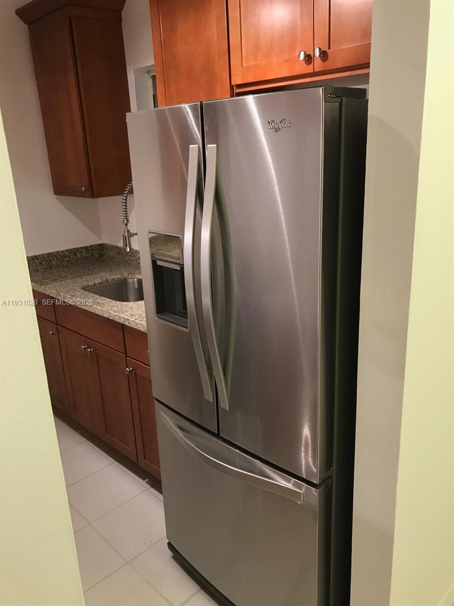 160 Southwest 30th Avenue, Unit 104A Miami, FL 33135 - Photo 21 of 24 a metallic refrigerator freezer sitting in a kitchen