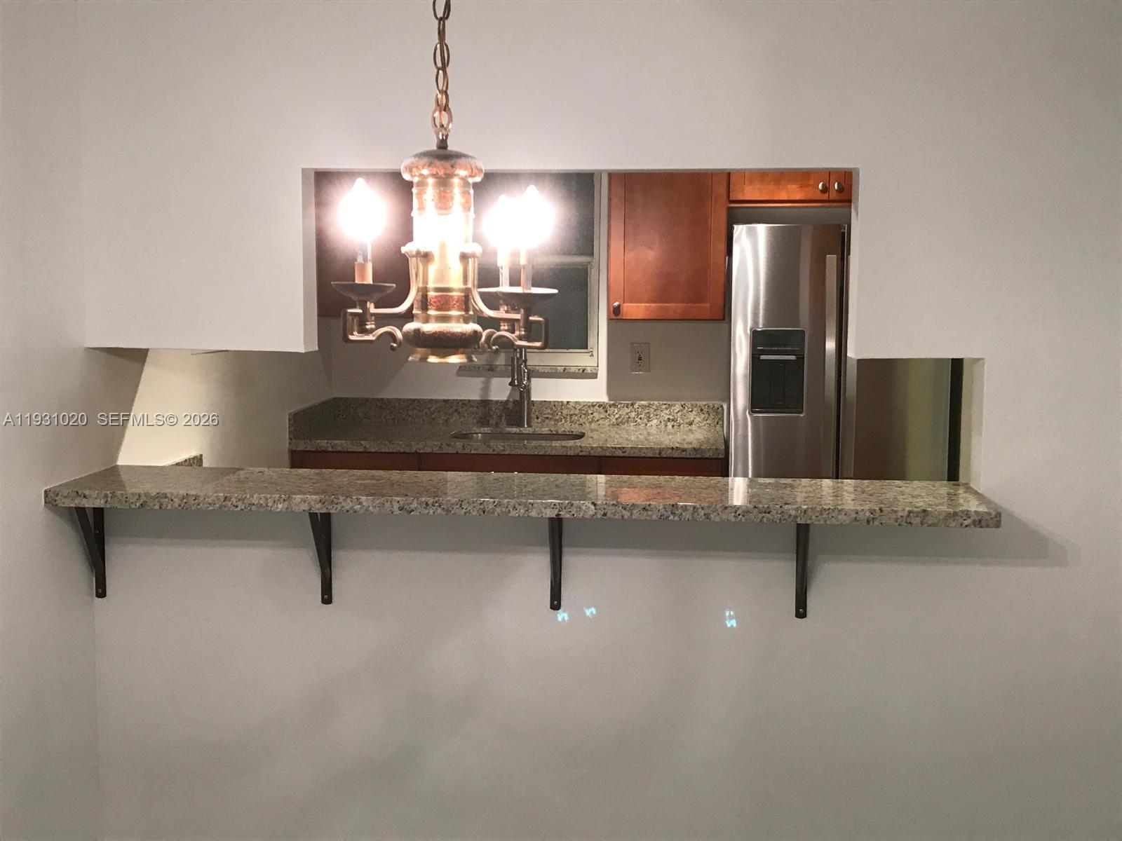 160 Southwest 30th Avenue, Unit 104A Miami, FL 33135 - Photo 23 of 24 a kitchen with stainless steel appliances a sink stove and granite counter top