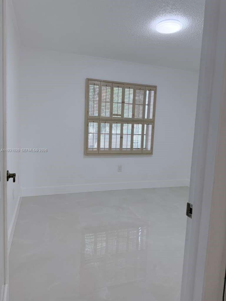 160 Southwest 30th Avenue, Unit 104A Miami, FL 33135 - Photo 26 of 32 a view of an empty room with a window